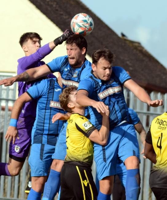 Heads you win, visiting keeper Edward King clears under pressure from a corner
